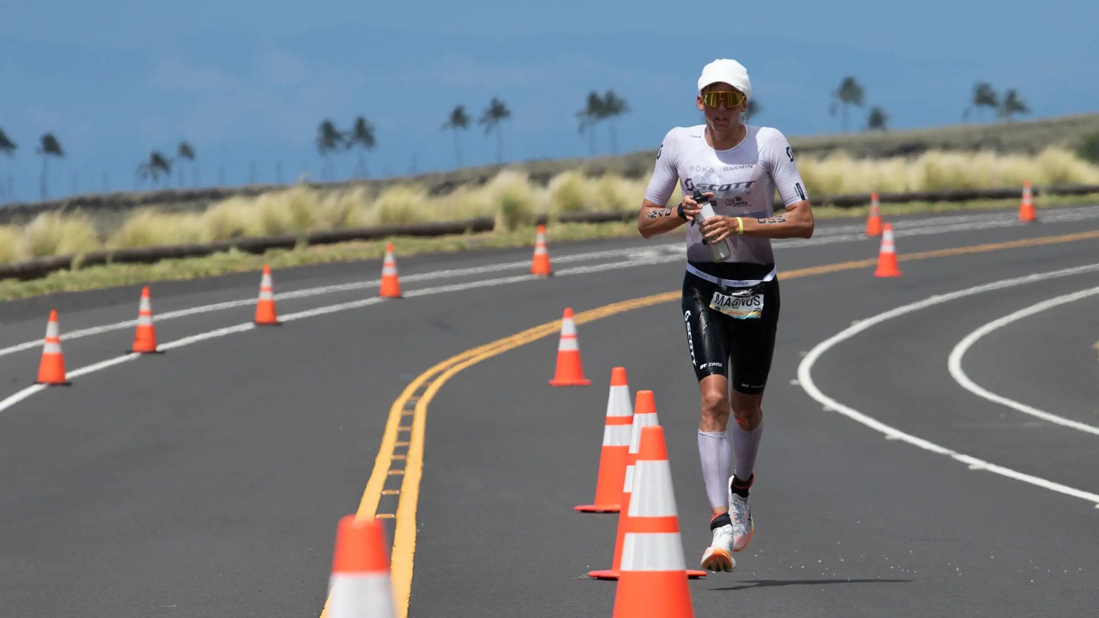 Magnus Ditlev 在 2026 Kona 馬拉松賽段，手上拿著水壺跑在 Queen K 公路上