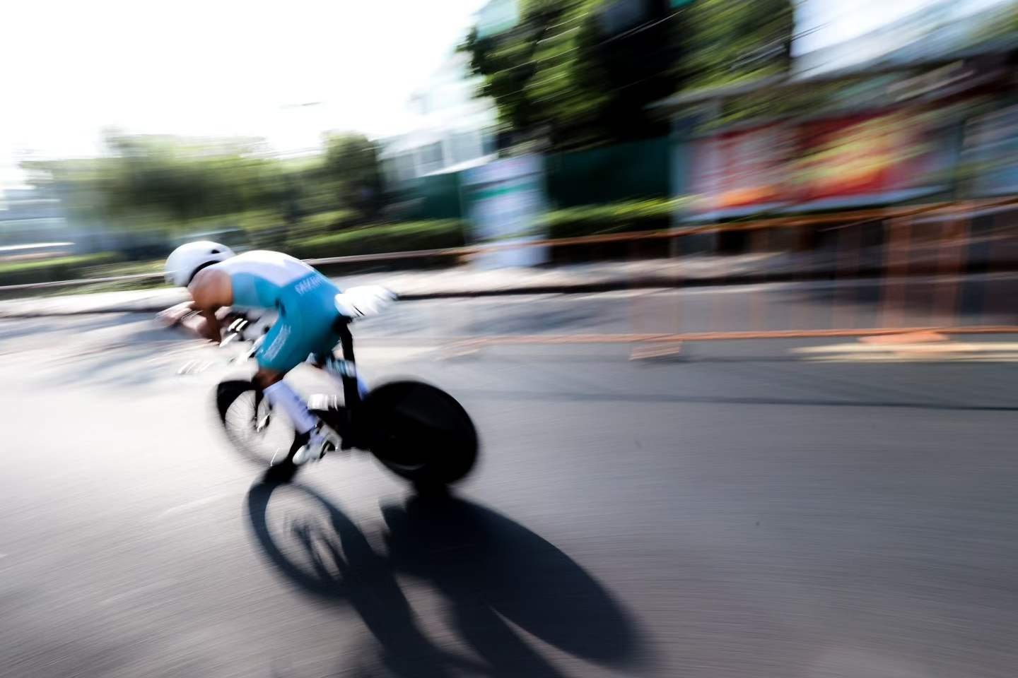 追焦鏡頭下高速通過的計時車選手，背景拉成流線